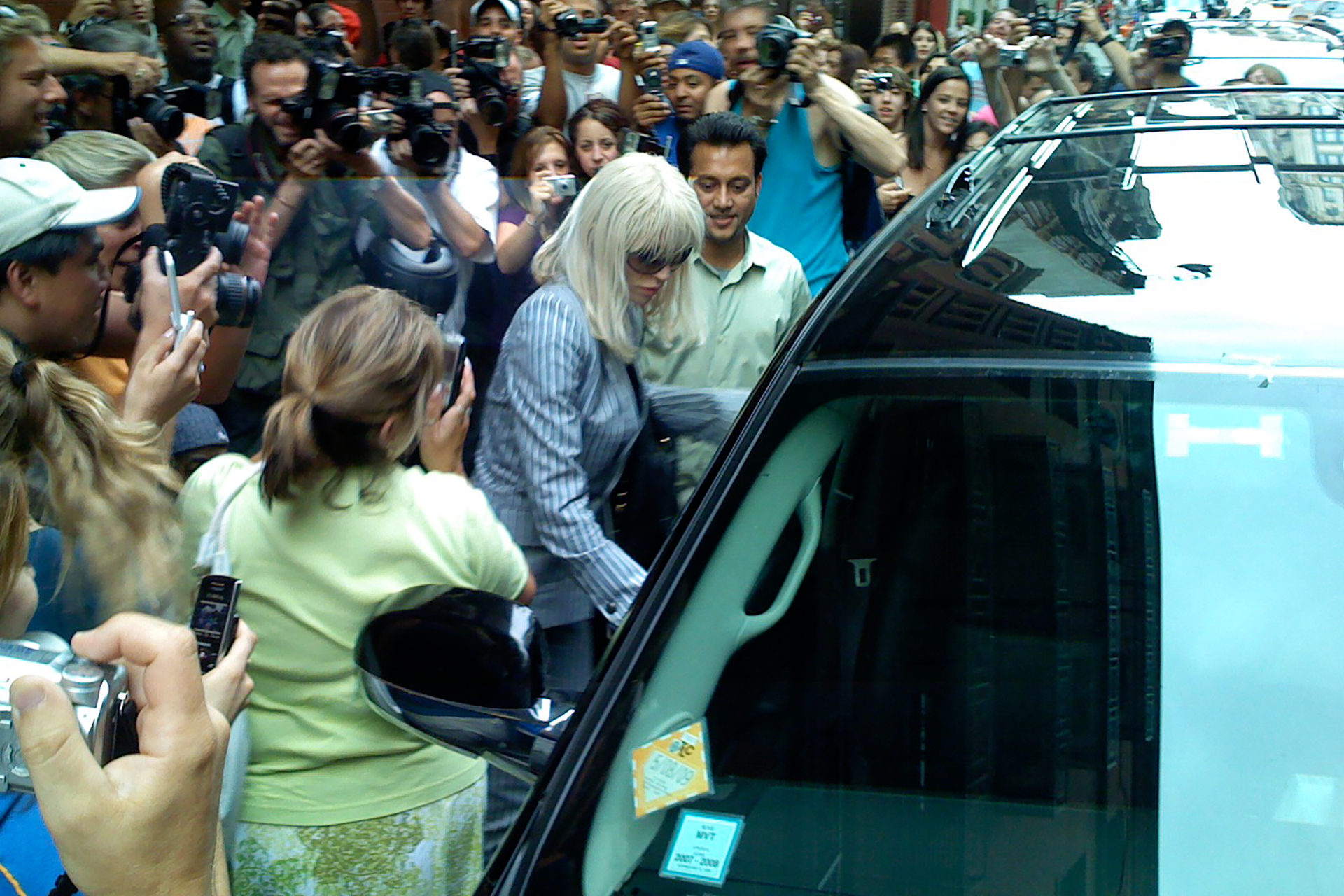 Courtney Love stepping into an SUV outside The Mercer Hotel in SoHo, surrounded by a frenzy of paparazzi photographers — the first paparazzi photo ever taken with an iPhone, July 13, 2007.